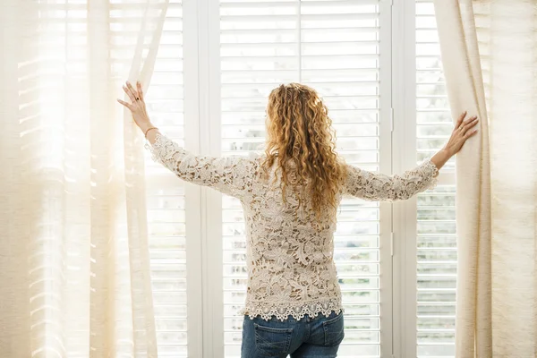 Donna che guarda fuori dalla finestra — Foto Stock