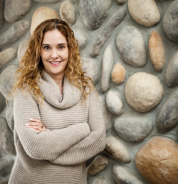 Mujer frente a la pared de piedra —  Fotos de Stock