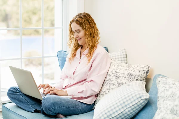 Mulher usando computador portátil em casa — Fotografia de Stock