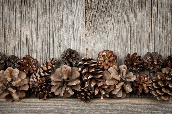 Rustikales Holz mit Tannenzapfen — Stockfoto