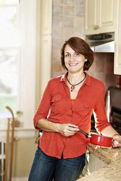 Mulher sorridente na cozinha em casa — Fotografia de Stock