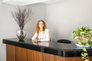 Smiling woman at office reception clipart