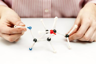 Student assembling molecule models clipart