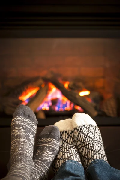 Feet warming by fireplace — Stock Photo, Image