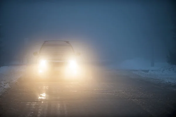 Headlights of car driving in fog — Stock Photo, Image