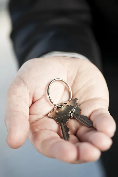 Hand het aanbieden van nieuwe sleutels — Stockfoto