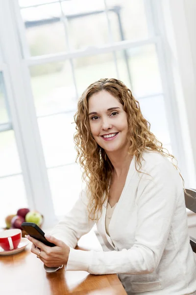 Mujer sonriente usando el teléfono inteligente — Foto de Stock