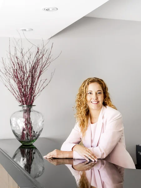 Lachende vrouw bij de receptie van het Bureau — Stockfoto