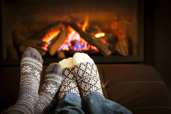 Füße wärmen am Kamin Stockfoto