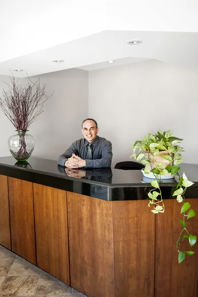 Sonriente hombre de pie en la recepción de la oficina — Foto de Stock