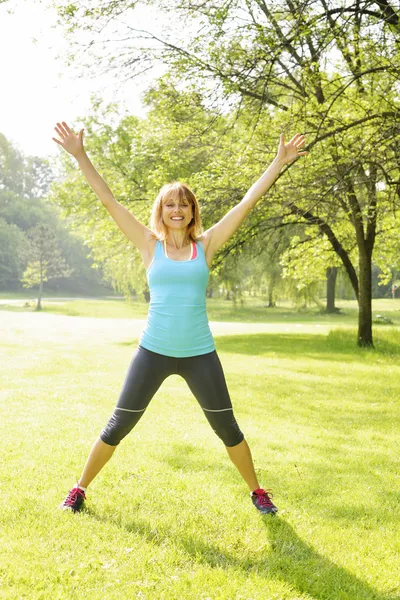 Femme souriante faisant de l'exercice dehors — Photo