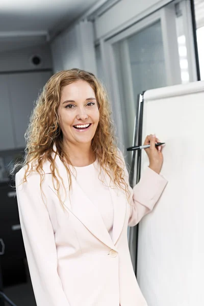 Femme d'affaires écrit sur tableau à feuilles mobiles — Photo