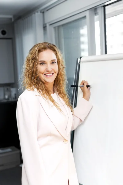 Mulher de negócios escrevendo no gráfico flip — Fotografia de Stock
