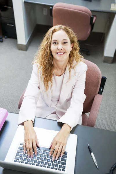 Mujer escribiendo en el ordenador portátil en el trabajo — Foto de Stock