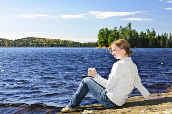 Jeune femme se relaxant au bord du lac — Photo