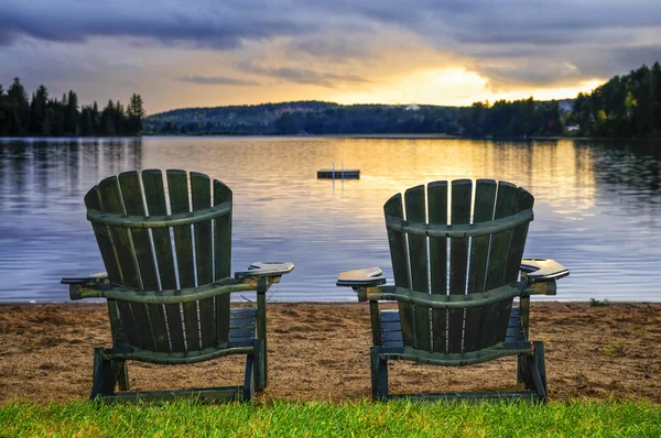 Sillas de madera al atardecer en la playa — Foto de Stock