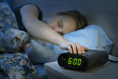Woman waking up early with alarm clock clipart