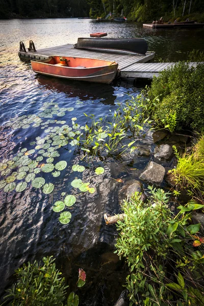 Roeiboot op de oever van het meer in de schemering — Stockfoto