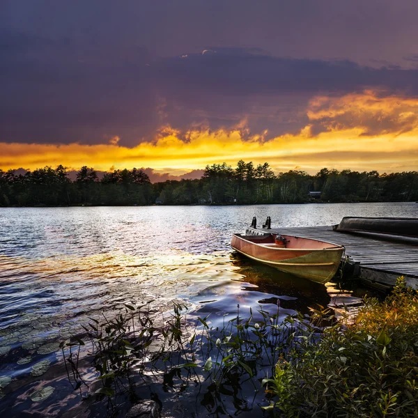 Boat docked on lake at sunset — Stock Photo, Image