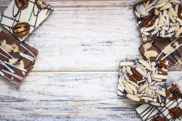 Chocolate bark on wood background — Stock Photo, Image