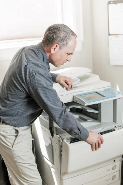 Hombre abriendo fotocopiadora en la oficina —  Fotos de Stock