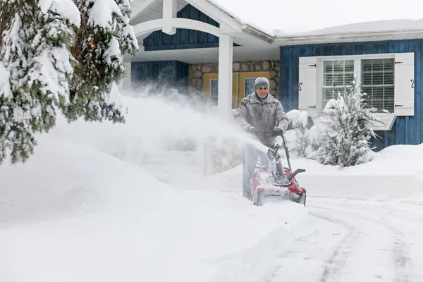 Homme utilisant une souffleuse à neige — Photo
