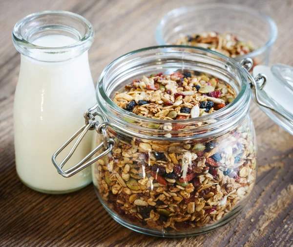 Glass jar of granola and milk — Stock Photo, Image