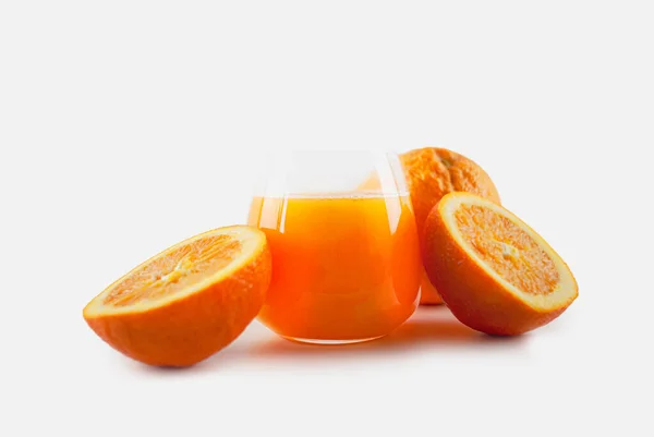 一杯新鲜榨橙汁 切片橙子 橙子切成两半 整个橙子在模糊的背景上 — 图库照片#