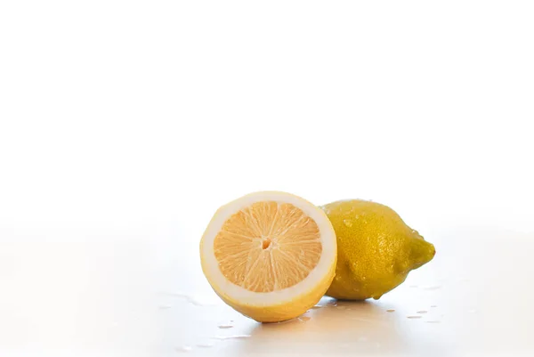 两个柠檬中的一个被切割成了前景 两个柠檬都被切割成了白色背景 — 图库照片#
