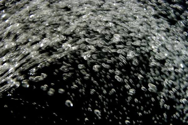Salpicaduras de agua sobre un fondo negro — Foto de Stock