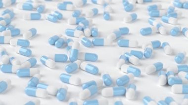 Mavi ve beyaz kapsüller parlak beyaz bir arkaplanda ilerliyorlar.