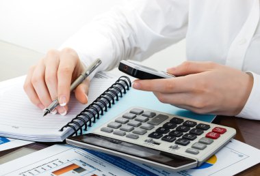 kalem ve presleme hesap makinesi düğmelerinin belgeler üzerinde tutan eller