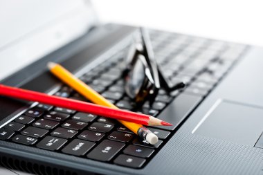 laptop klavye ve pencills ve gözlük