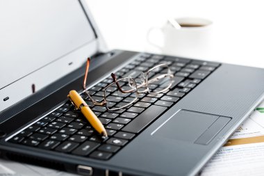 laptop klavye ve kalem ve gözlük