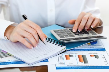 kalem ve presleme hesap makinesi düğmelerinin belgeler üzerinde tutan eller