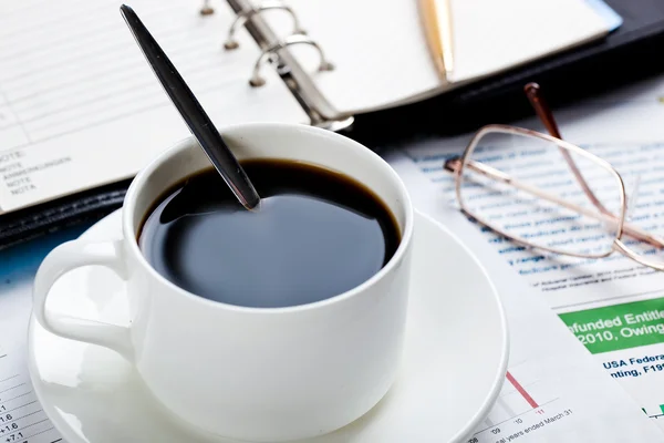 Primer plano de documentos, bolígrafo, taza de café sobre la mesa — Foto de Stock