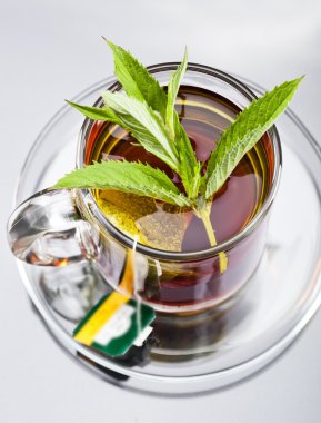 bardak yeşil çay ve yeşil yaprakları ile.