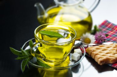 bardak yeşil çay ve yeşil yaprakları ile.