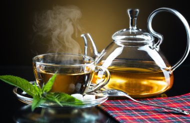 bardak yeşil çay ve yeşil yaprakları ile.