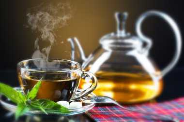 bardak yeşil çay ve yeşil yaprakları ile.