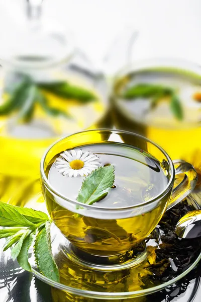 Copo com chá verde e folhas verdes . — Fotografia de Stock
