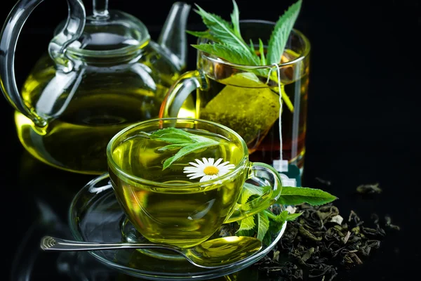 Taza con té verde y hojas verdes . — Foto de Stock