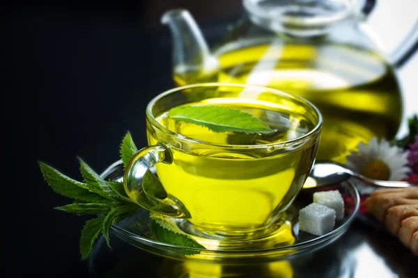 Cup with green tea and green leaves. — Stock Photo, Image