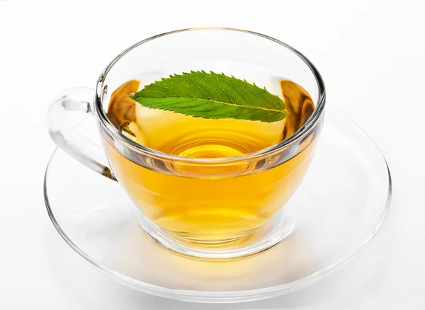 Cup with green tea and green leaves. — Stock Photo, Image