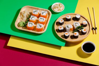 Parlak, renkli arka planda bir tabakta suşi..