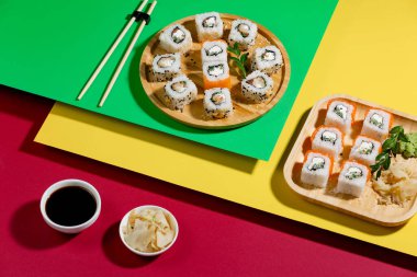 Parlak, renkli arka planda bir tabakta suşi..