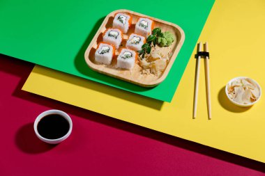 Parlak, renkli arka planda bir tabakta suşi..