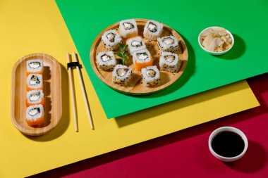 Parlak, renkli arka planda bir tabakta suşi..