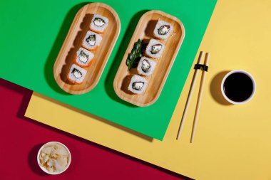 Sushi on a plate on a bright, colored background.