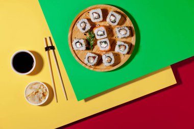 Sushi on a plate on a bright, colored background.